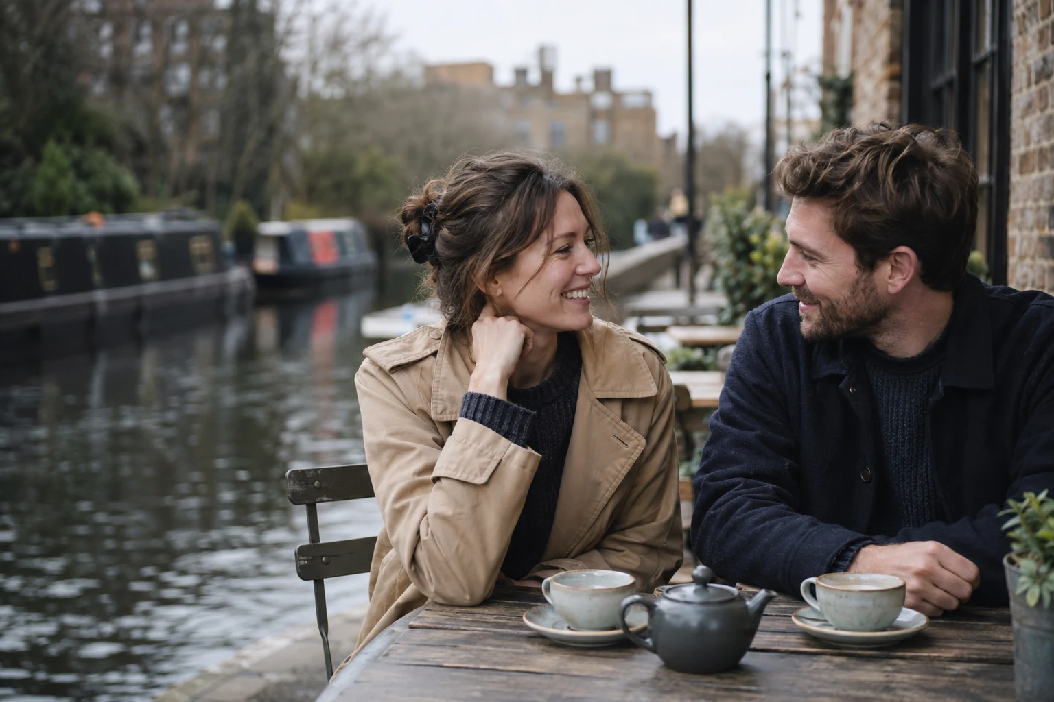 Illustrative English adult couple talking at a London canal-side café